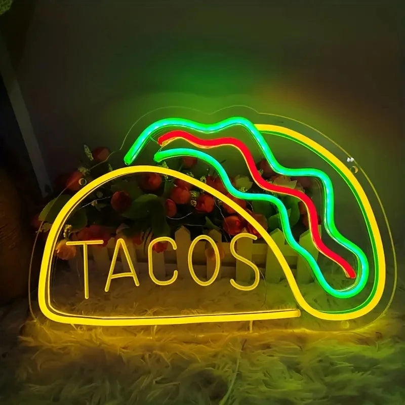 Neon sign shaped like a taco with 'TACOS' text on a dark background