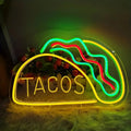 Neon sign shaped like a taco with 'TACOS' text on a dark background