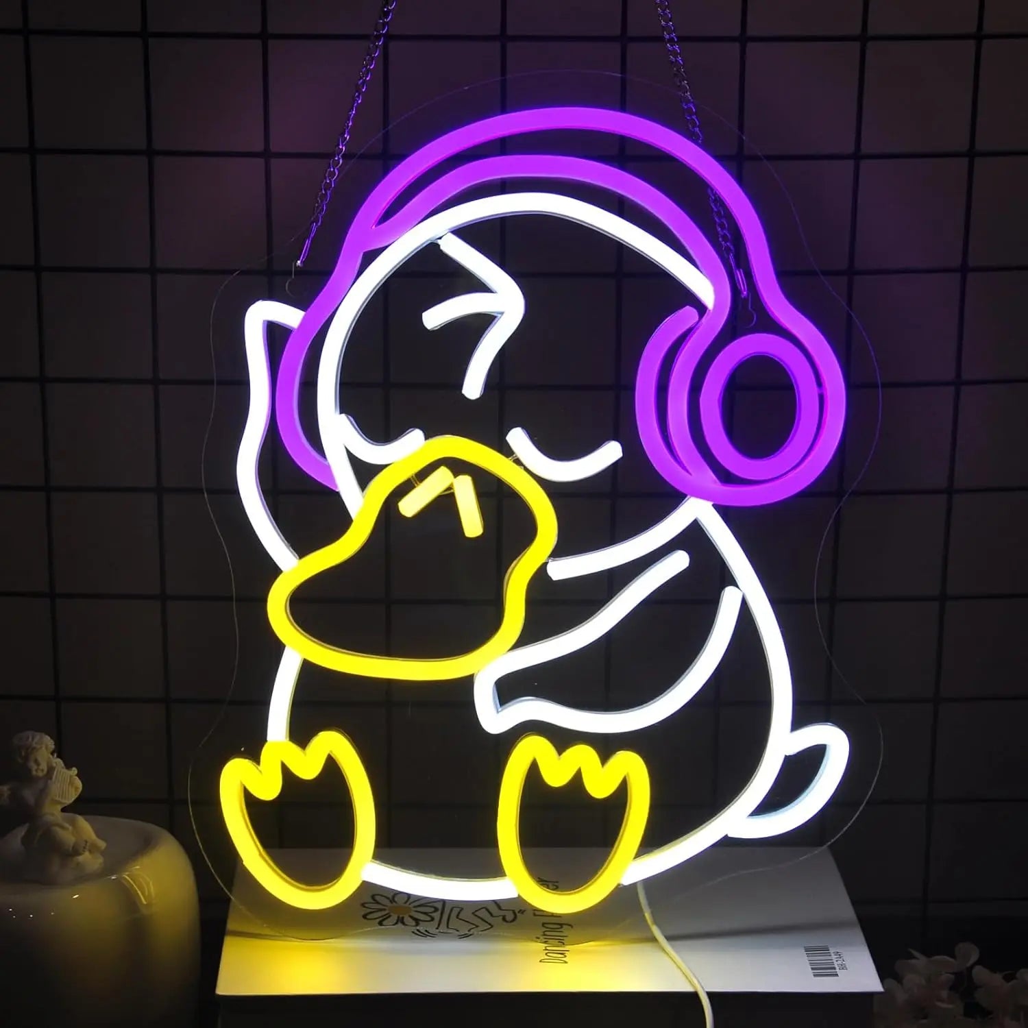 Neon light shaped like a cartoon character with headphones on a dark tiled wall background