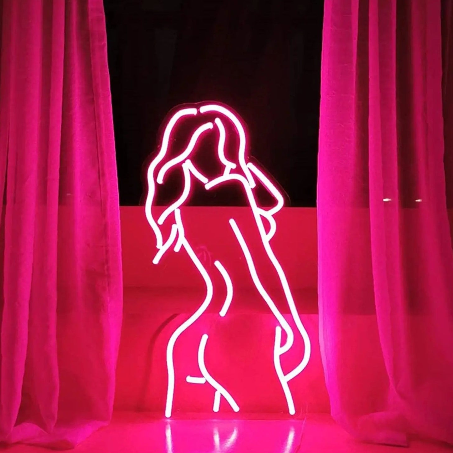 Neon outline of a person against a red curtain backdrop