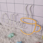 Neon sign with 'Coffee' text and a coffee cup shape on a checkered floor.