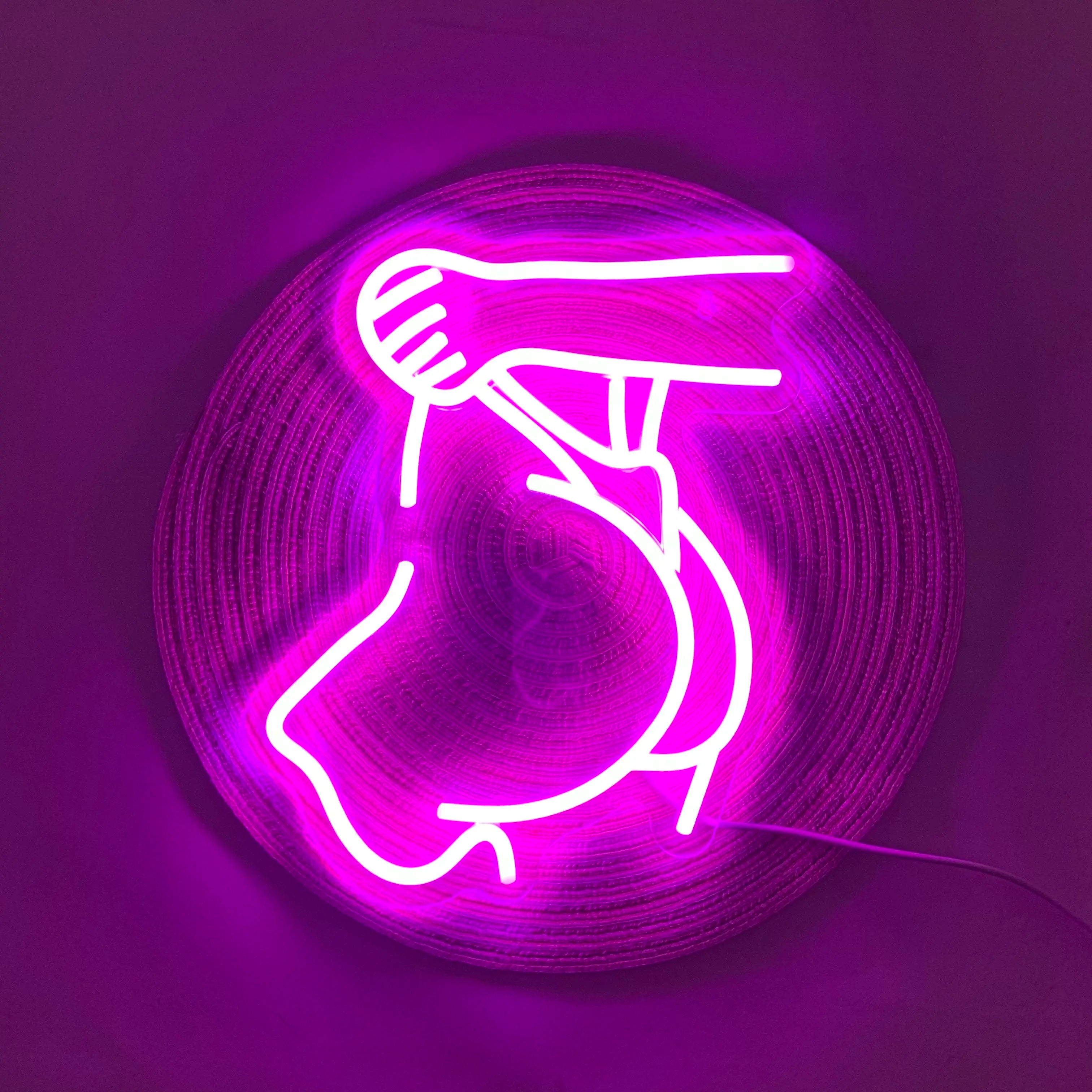 Neon sign of a hand holding a phone on a purple background