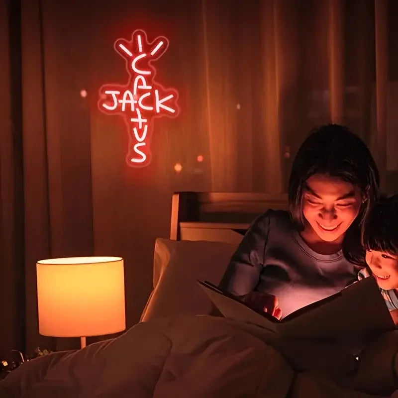 Two people reading a book in a dimly lit room with a neon sign in the background.