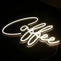 Neon sign with the word 'Coffee' on a black background