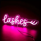 Neon sign with the word 'lashes' on a dark background
