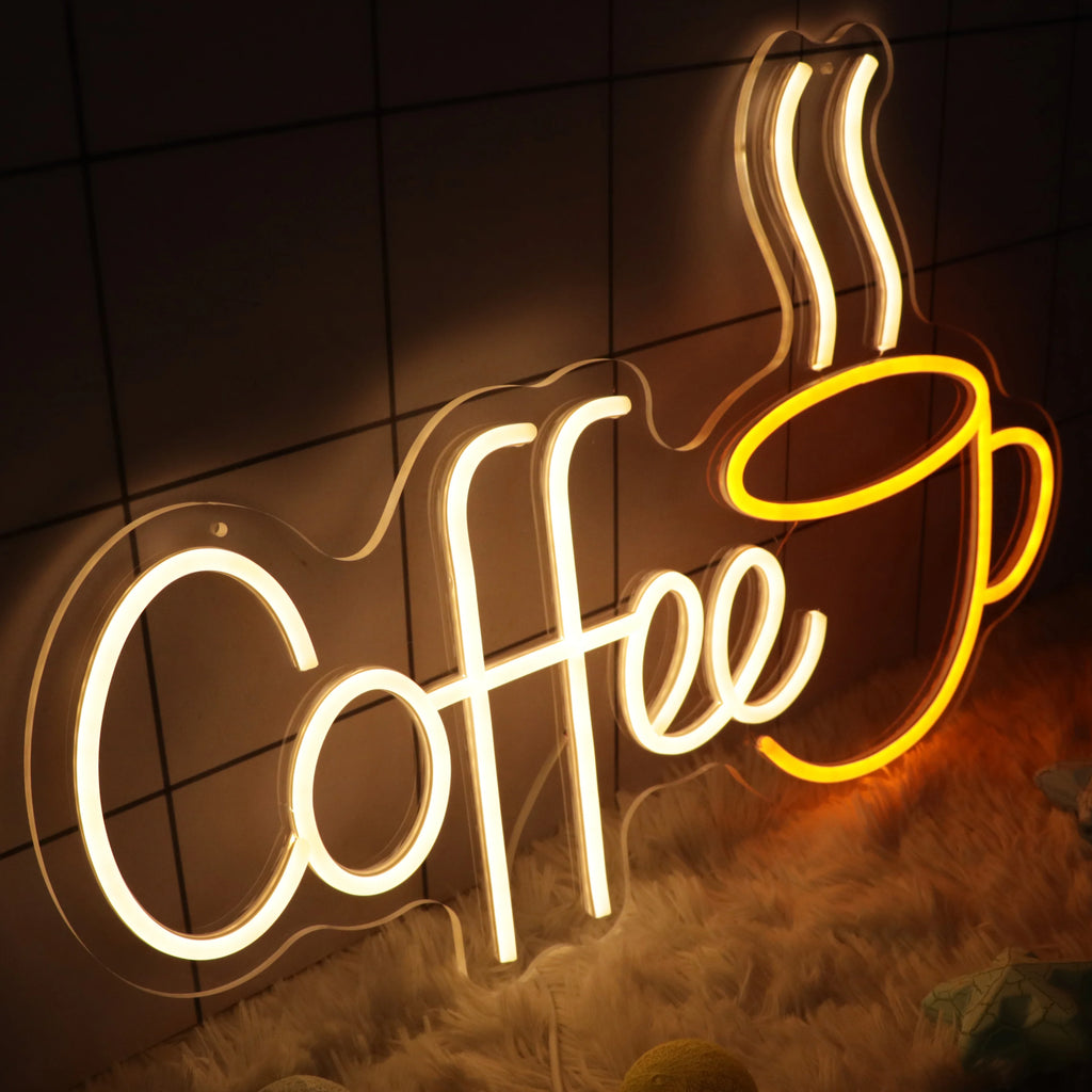 Neon sign with the word 'Coffee' and a coffee cup on a tiled wall.