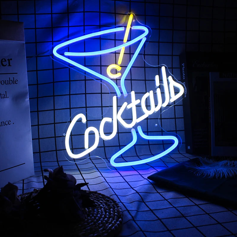 Neon sign shaped like a cocktail glass with 'Cocktails' text on a tiled wall.