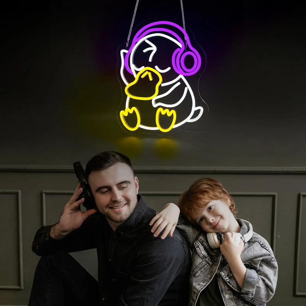Two people sitting together with a neon sign of a duck wearing headphones above them.