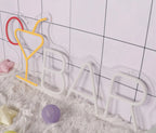 Decorative letter 'BAR' with colorful heart-shaped hooks on a tiled wall.