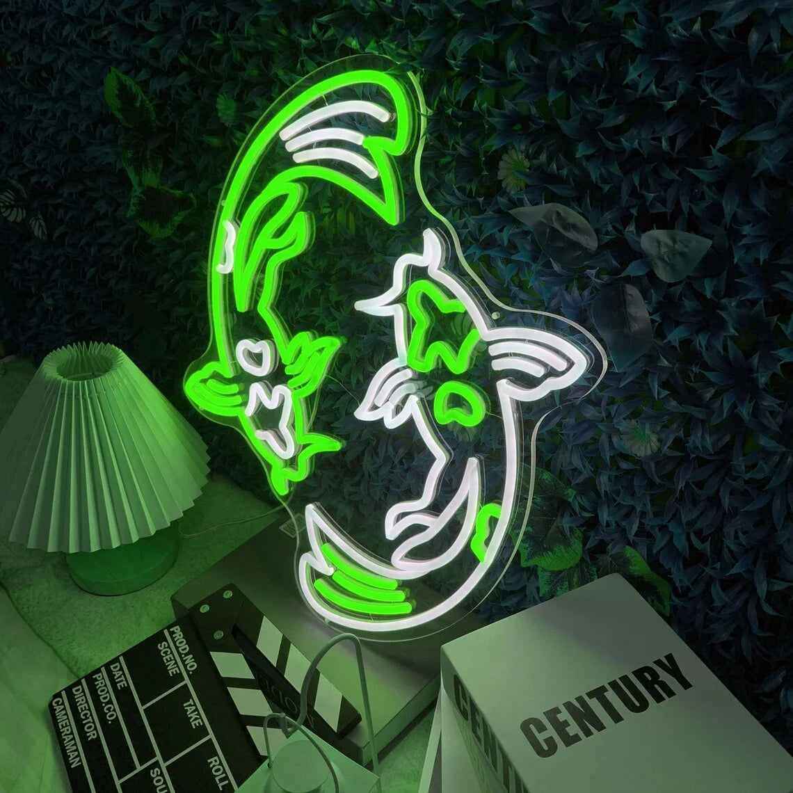 Neon sign shaped like a fish with green and white colors on a dark background.