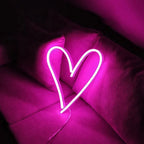 Neon heart-shaped light on a purple background